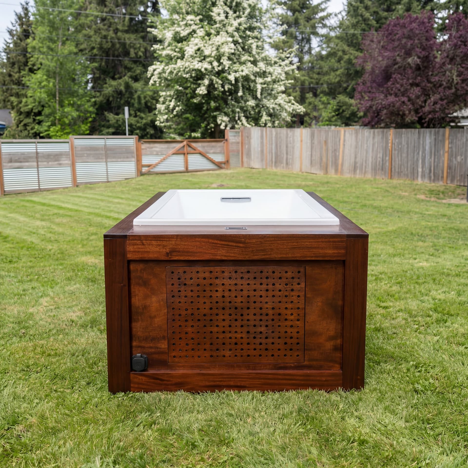Mahogany cold plunge and white bathing basin in the backyard, with its vented enclosure facing forward