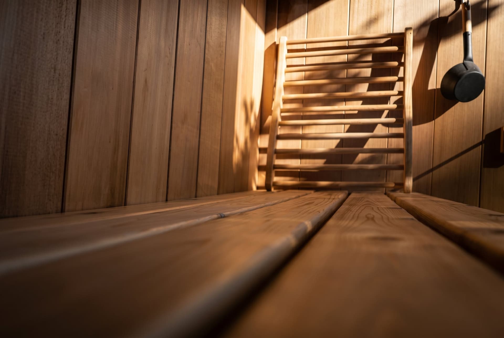Sunlight across the cedar sauna bench and slatted backrest